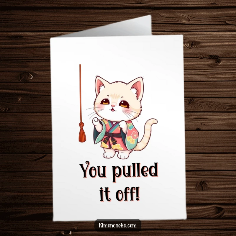 Funny Free Printable Congrats Card: Mischievous kitten in a vibrant kimono, eyes locked on a dangling string, celebrating success.