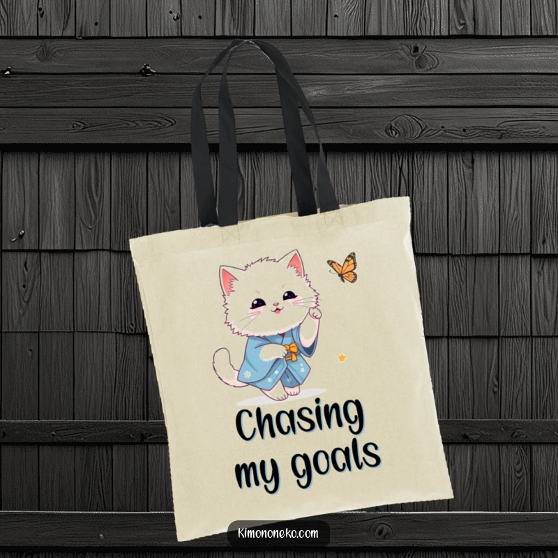 Funny fluffy white kawaii cat in a blue kimono playfully chasing a butterfly, showcasing a whimsical scene on a functional tote bag.